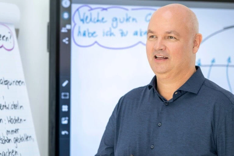 Ingo Steinke erkärt in der Coachingausbildung die Coaching- und Trainingsprinzipien am Smartboard bei COATRAIN® in Hamburg